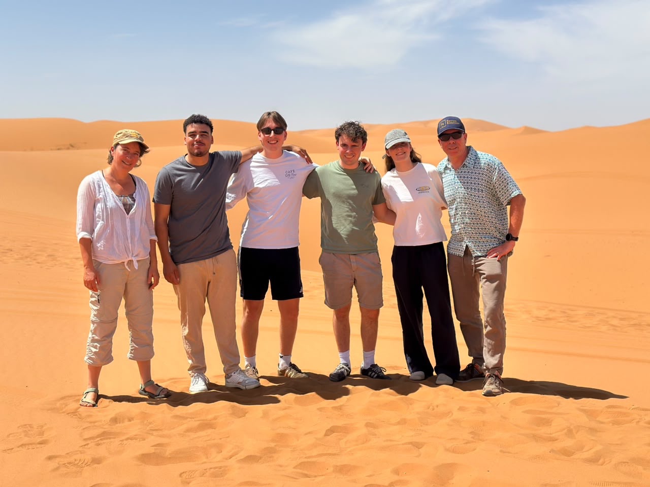 Travellers together among the Sahara dunes in Morocco